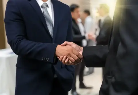 Business professionals shaking hands after a corporate agreement
